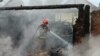 In this handout photograph taken and released by the Ukrainian Emergency Service on June 5, 2025 a rescuer extinguishes a fire following a drone strike in Pryluky, Chernihiv region, amid the Russian invasion of Ukraine.